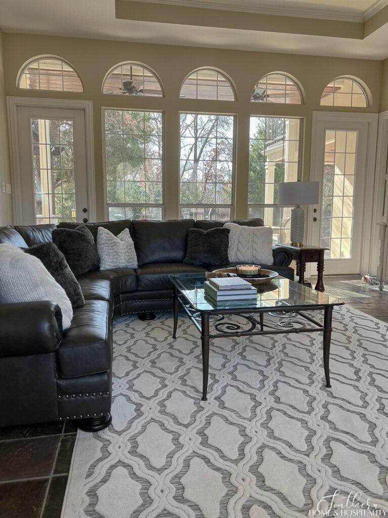 Geometric white and gray area rug and leather sofa