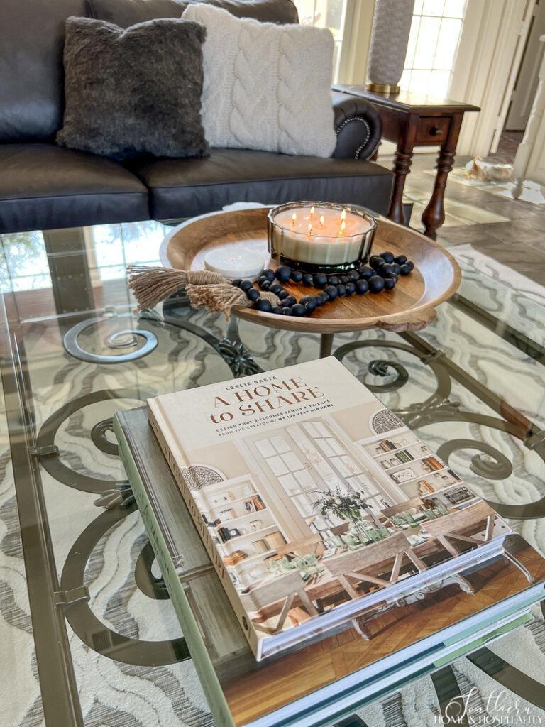 Seasonless coffee table styling with books, wood tray and a wood bead garland