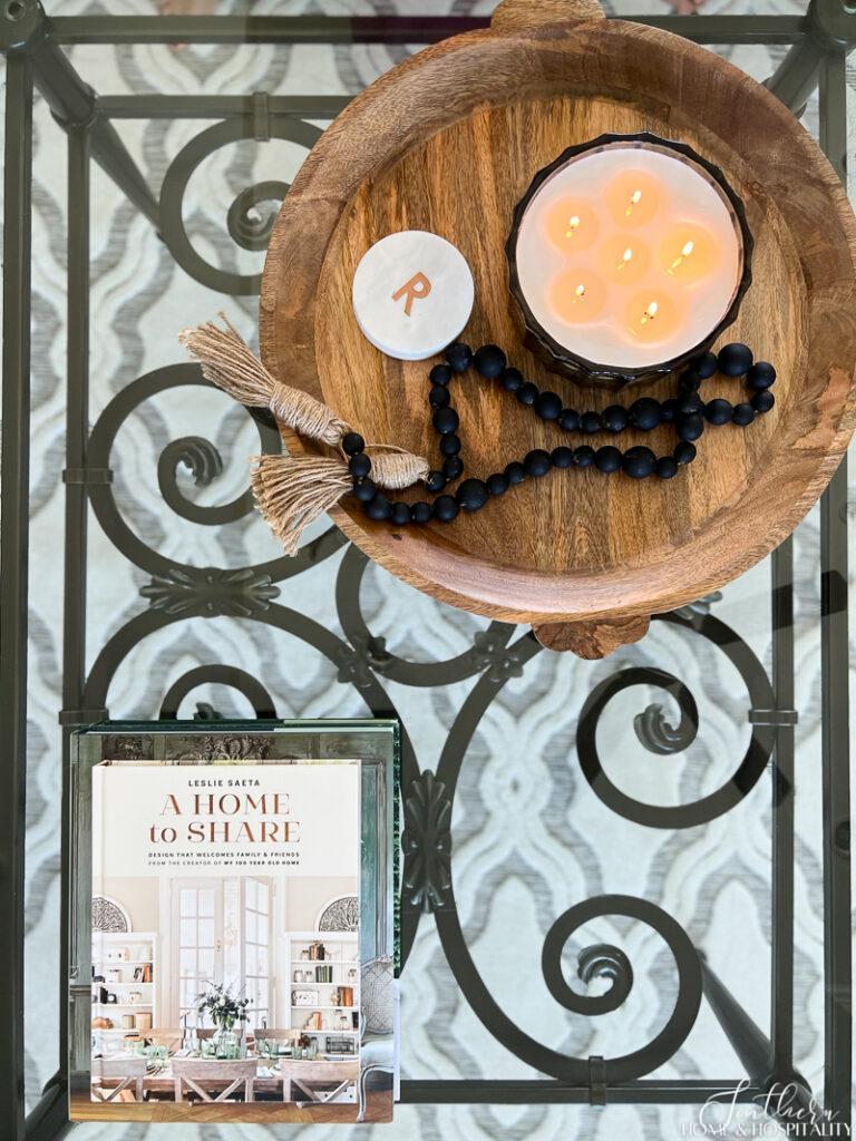 Coffee table decor with wood tray, candle, black bead garland, and coffee table books