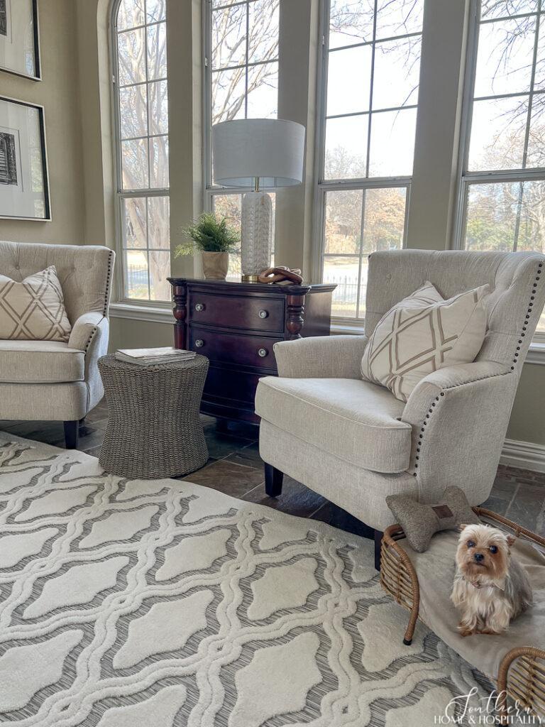 Yorkie in rattan dog bed on white and gray geometric area rug