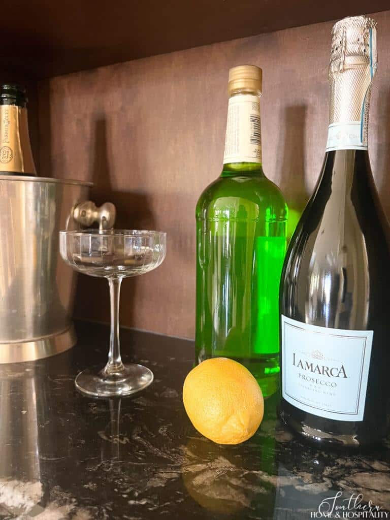 Ingredients for Sparkling Shamrock, melon liqueur, champagne, lemon, champagne coupe glass