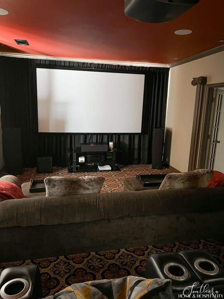 Black drapes behind screen in media room with red ceiling