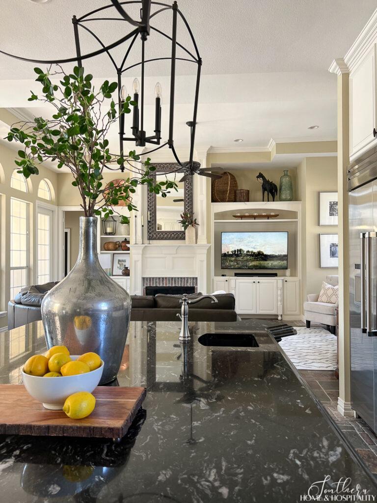 Traditional kitchen open to family room with a bowl of lemons on the counter