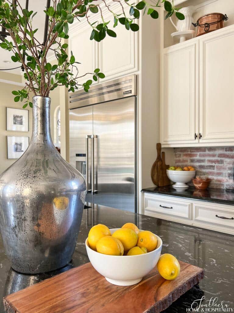 Bowl of lemons and green plant staged on kitchen island