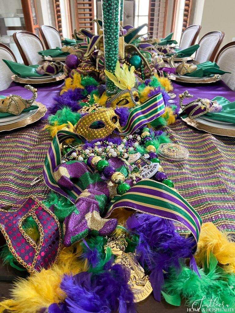 Mardi Gras tablescape with masks, beads, and feathers