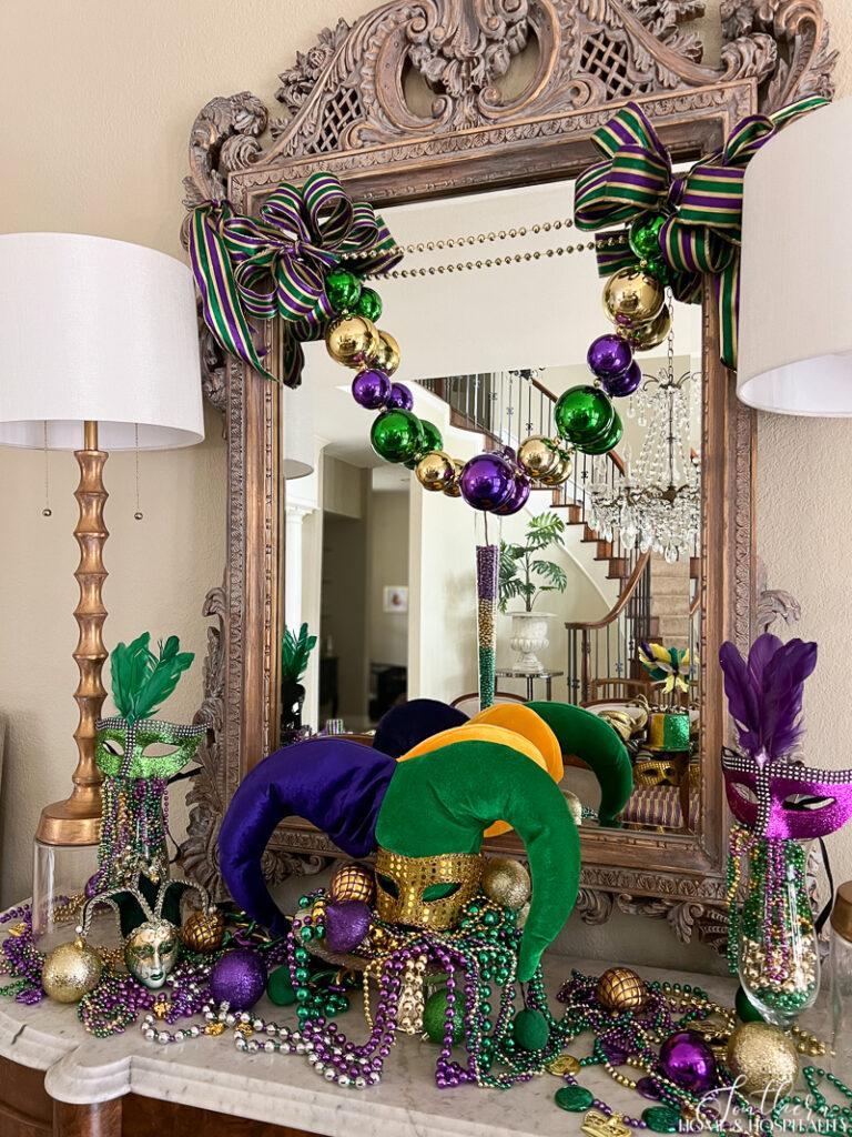 Mardi Gras ribbon and jumbo beads on dining room mirror and mardi gras decor on sideboard
