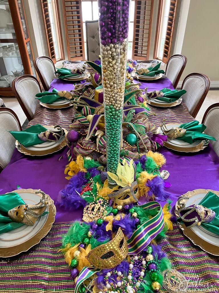 Fat Tuesday dining table theme with beads, masks, purple tablecloth, deco mesh