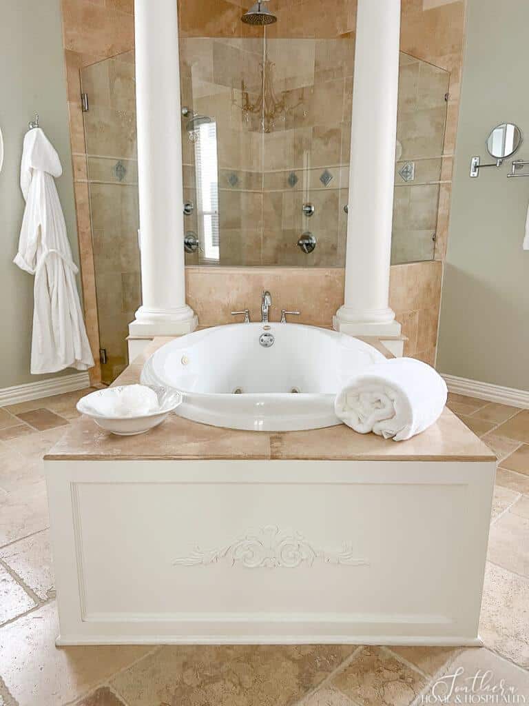 Jetted bathtub with travertine and wood surround 