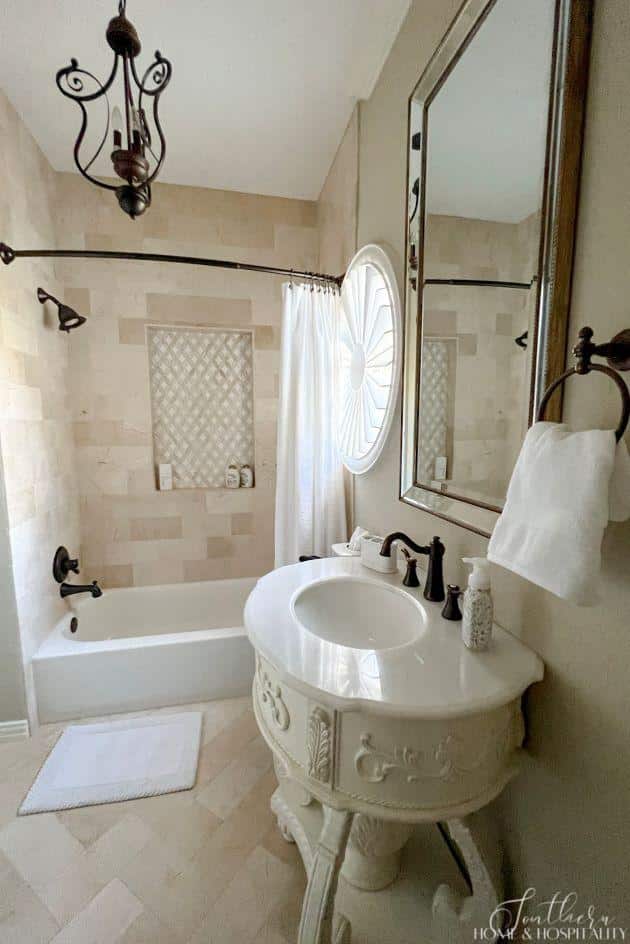 Beige marble tile in bathroom with curved furniture vanity
