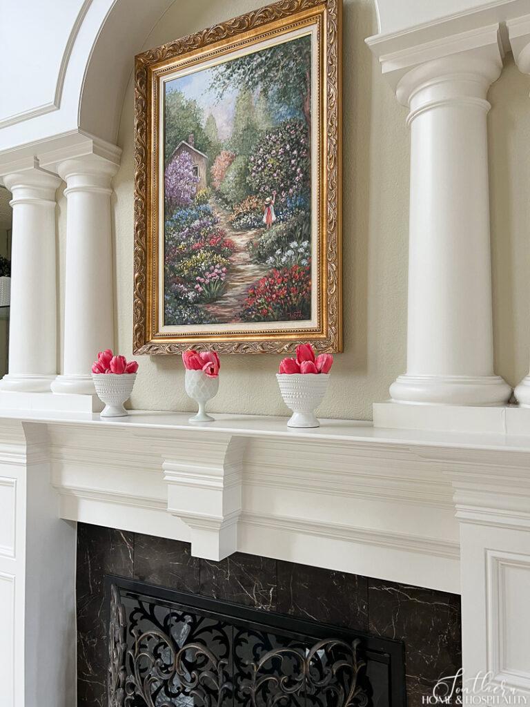 Pink tulips in white vases on mantel