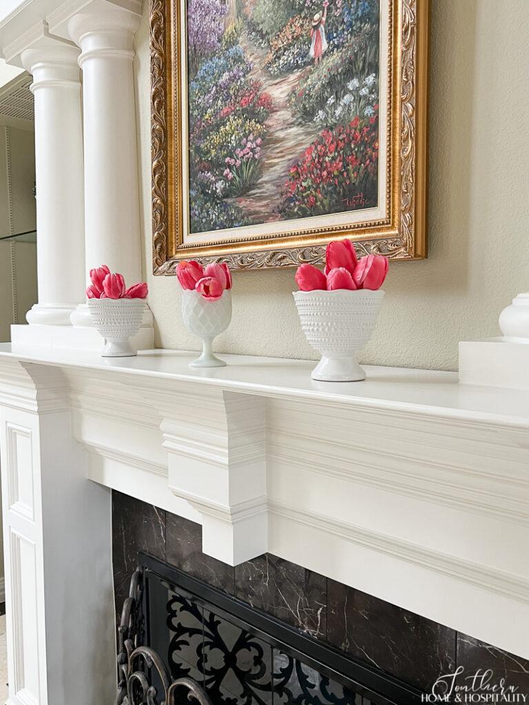 Spring mantel decor with pink tulips and milk glass