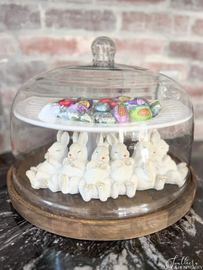 Napping rabbits decor under glass dome with Easter treats