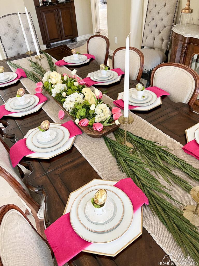 Pink and green spring tablescape with dough bowl, palms, gold eggs