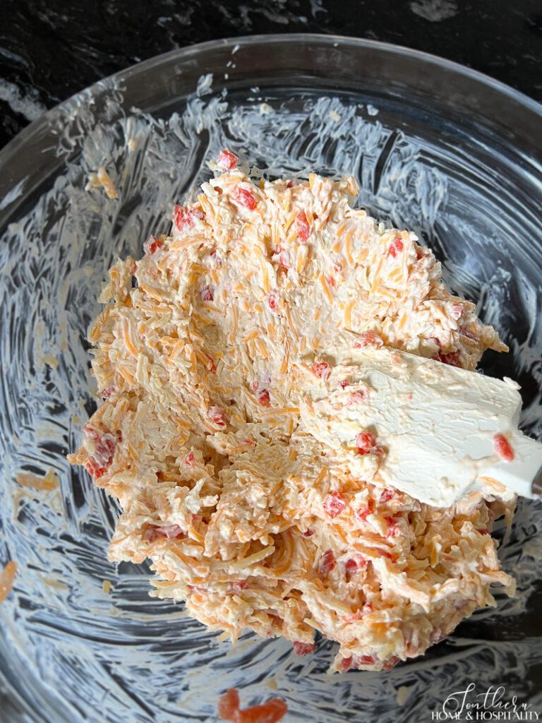 Mixing pimiento cheese ball ingredients in a bowl