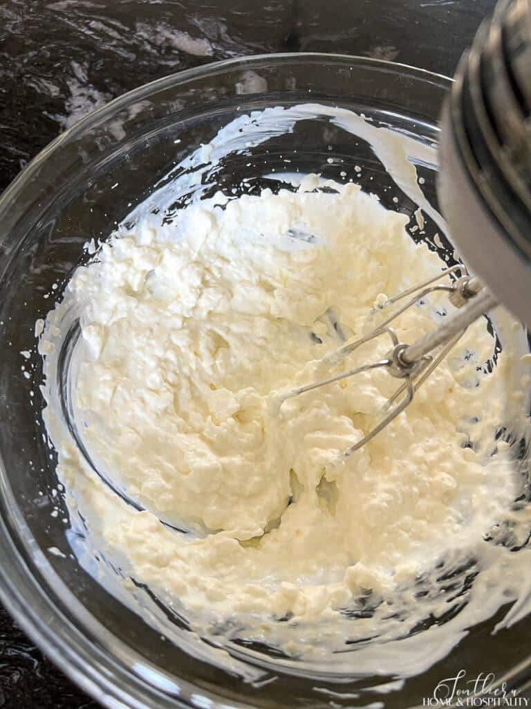 Mixing cream cheese, mayonnaise, and sour cream with a mixer