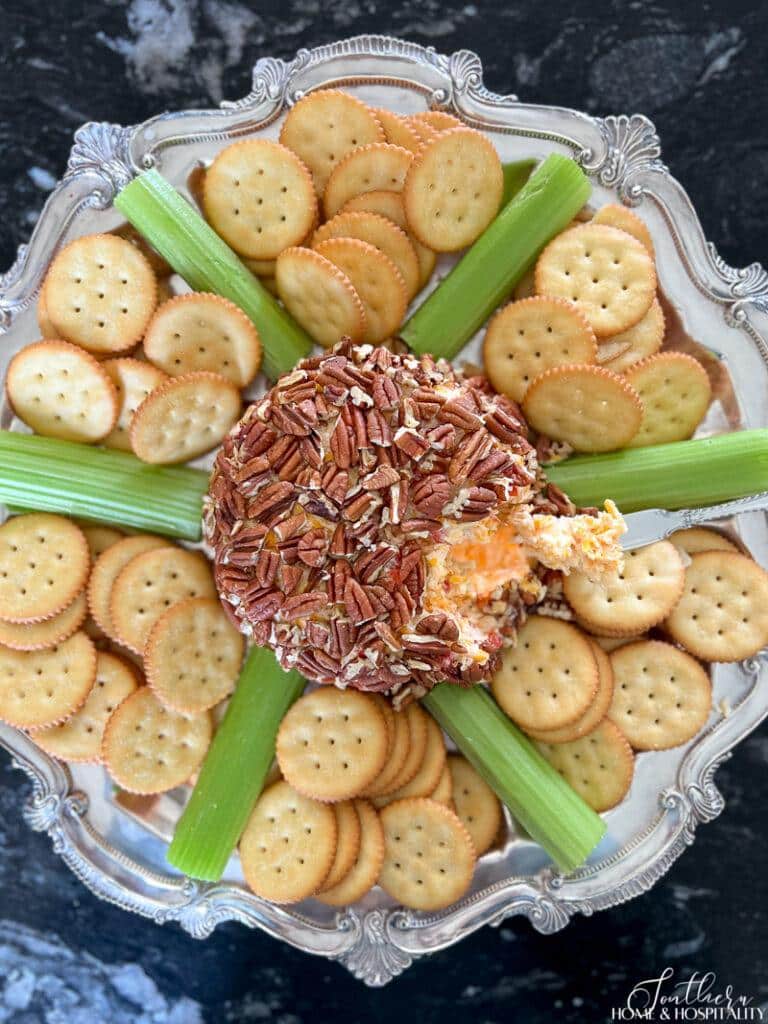 Pimento cheese ball on silver tray with crackers and celery