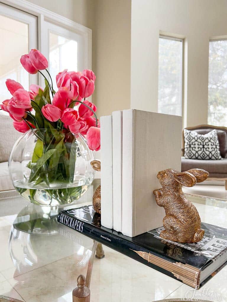 Gold rabbit bookends and pink tulips on spring coffee table
