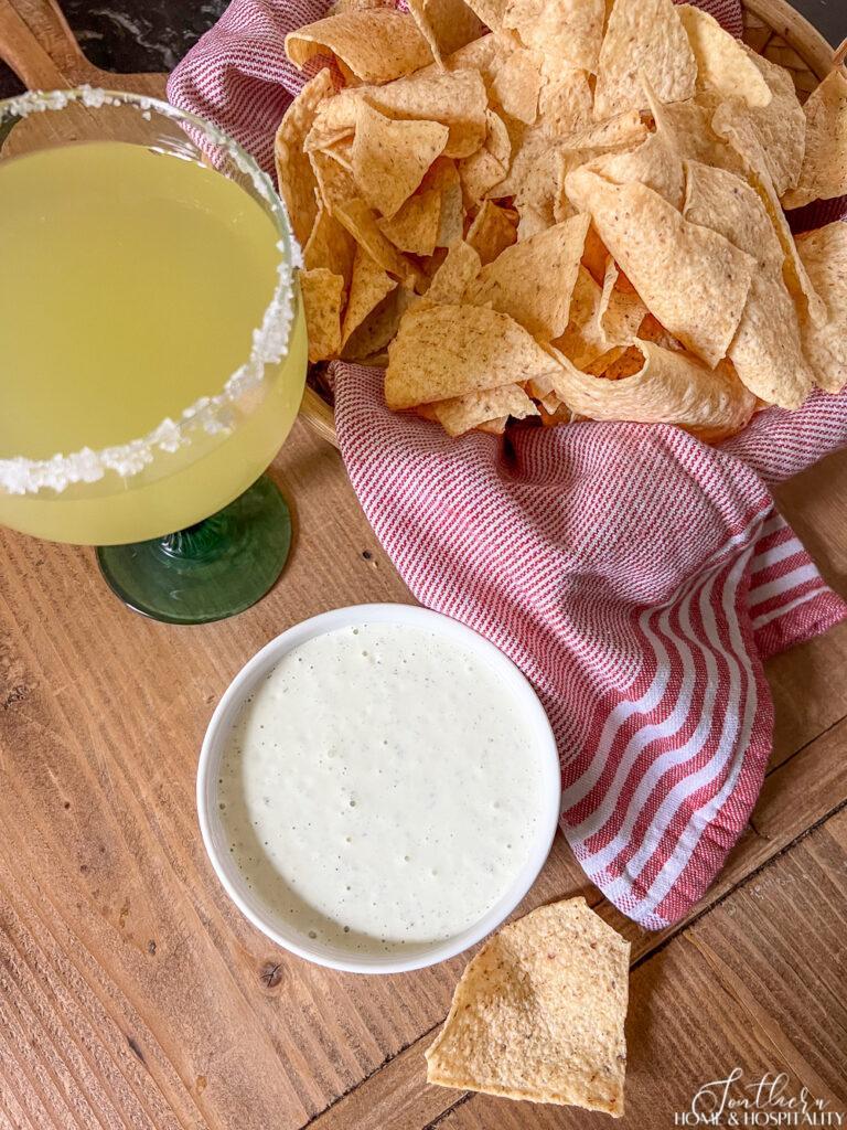 Chuy's creamy jalapeno copycat recipe with chips and a margarita