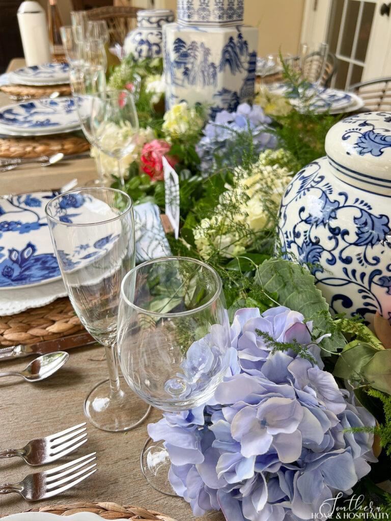 Blue hydrangea and wine glasses on dining table
