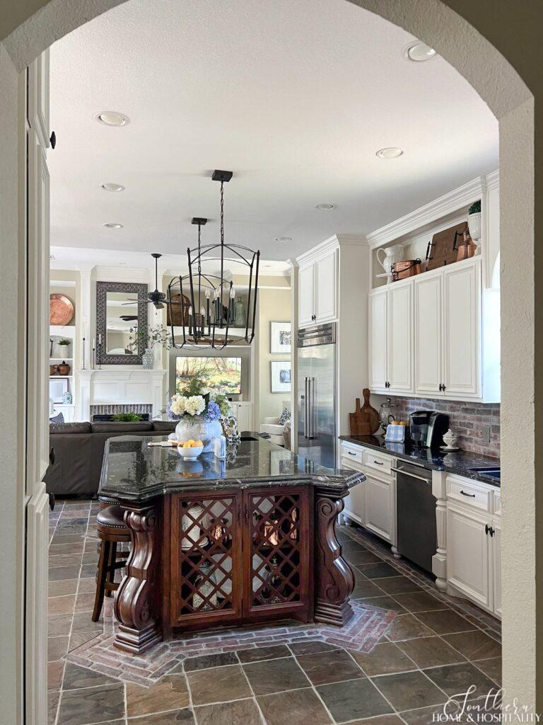 French country kitchen with stained wood island and white cabinets