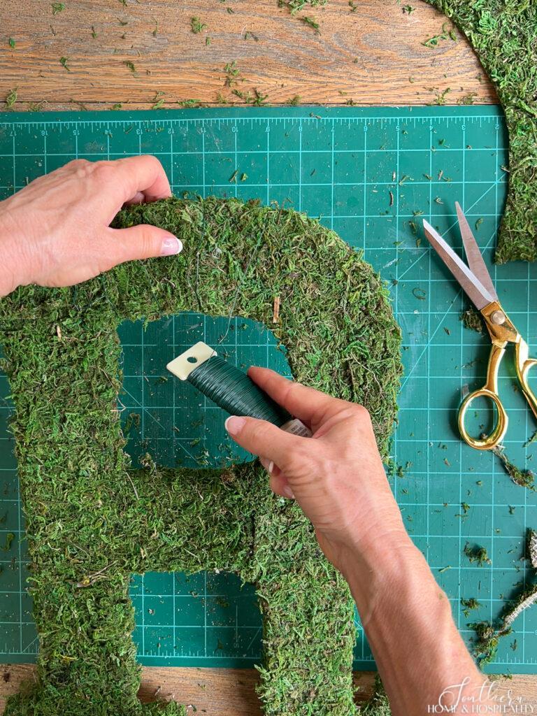 wrapping floral wire around moss letter