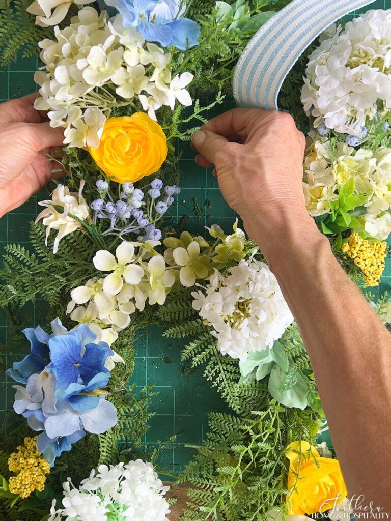 Attaching flowers to moss monogram wreath with floral wire