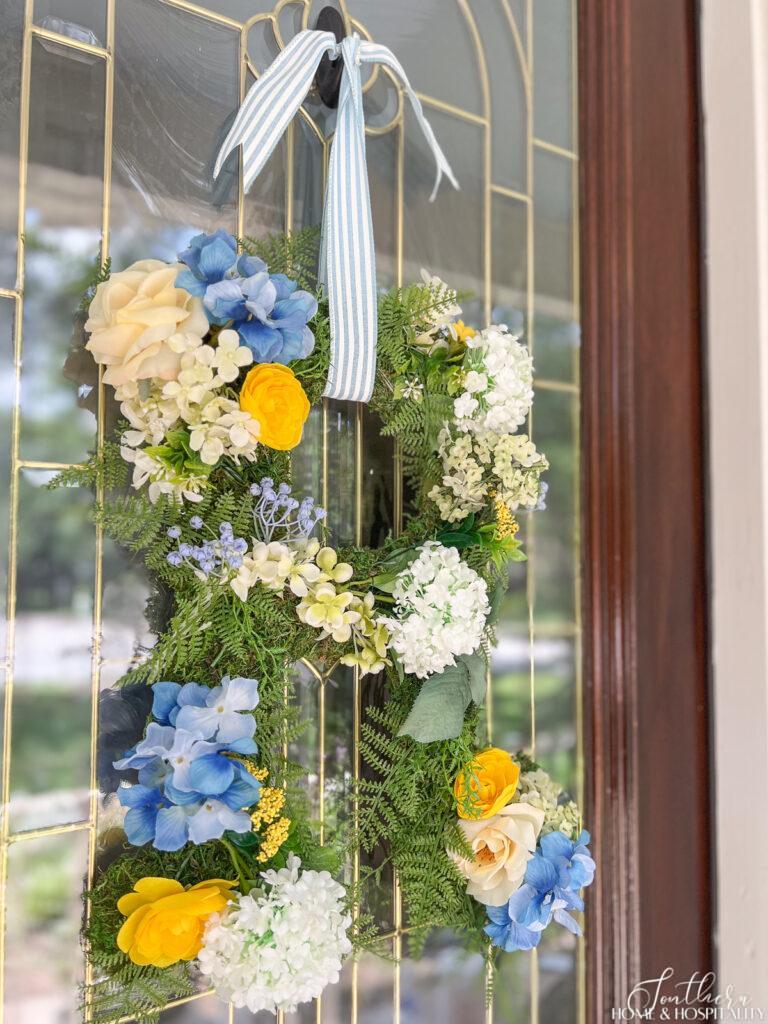 Summer Monogram Door wreath with blue, yellow, and white flowers