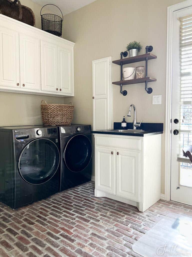 Laundry room with brick floor and laundry basket on washer dryer