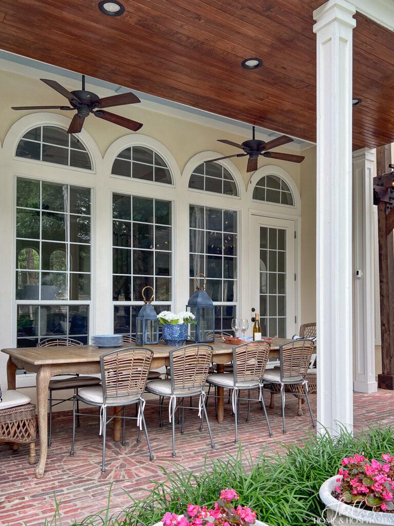 Southern back porch with French country dining table and brick floors
