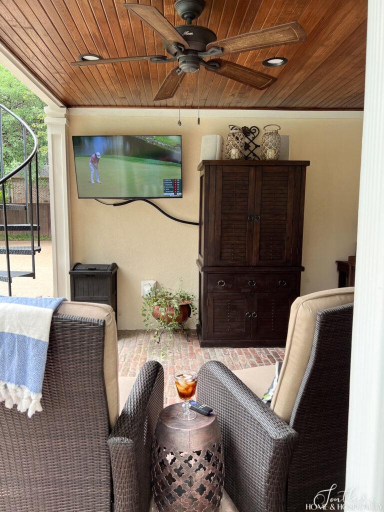 Outdoor wicker recliners and tv on covered patio