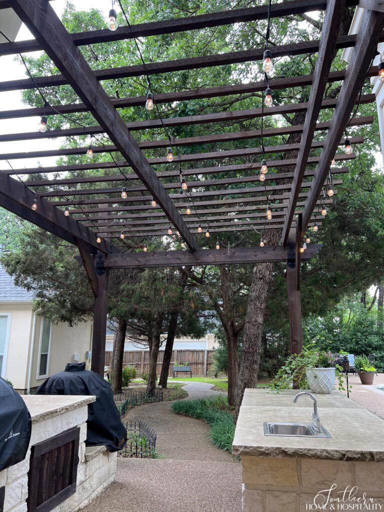 String lights on pergola over outdoor kitchen
