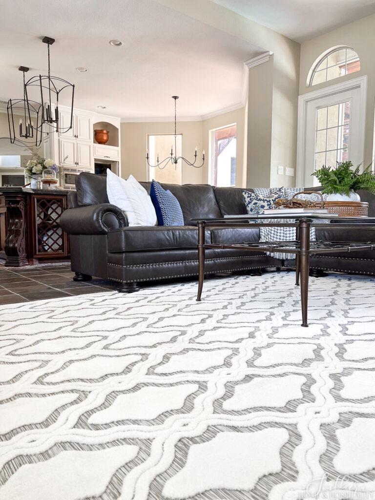 Geometric white and gray area rug under leather sofa
