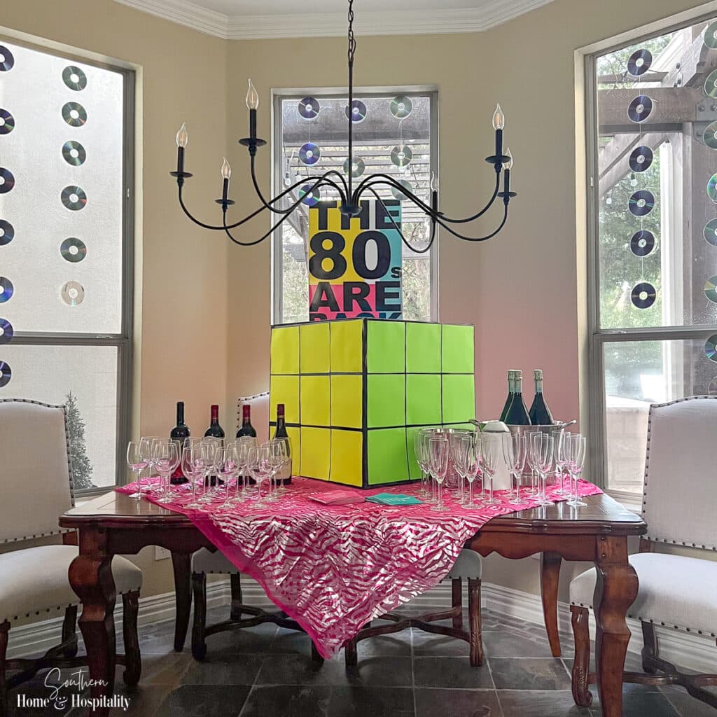 80s party wine station with large rubik's cube and CD garlands