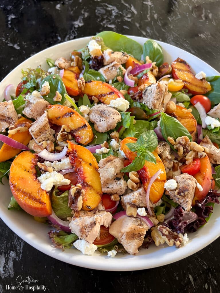 Grilled peach summer salad with chicken, basil, mint, and balsamic