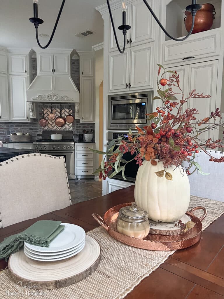 Fall decor on kitchen table with white pumpkin vase