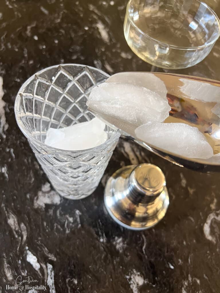 Adding ice to a glass cocktail shaker