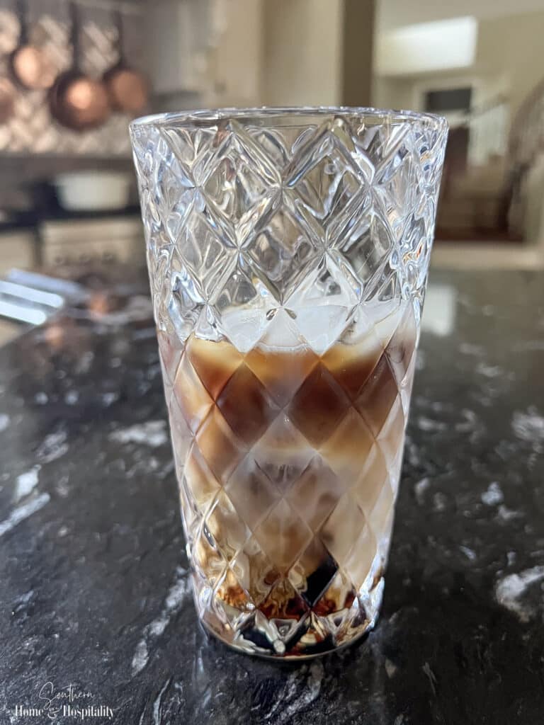 Glass cocktail shaker with cold brew espresso martini ingredients