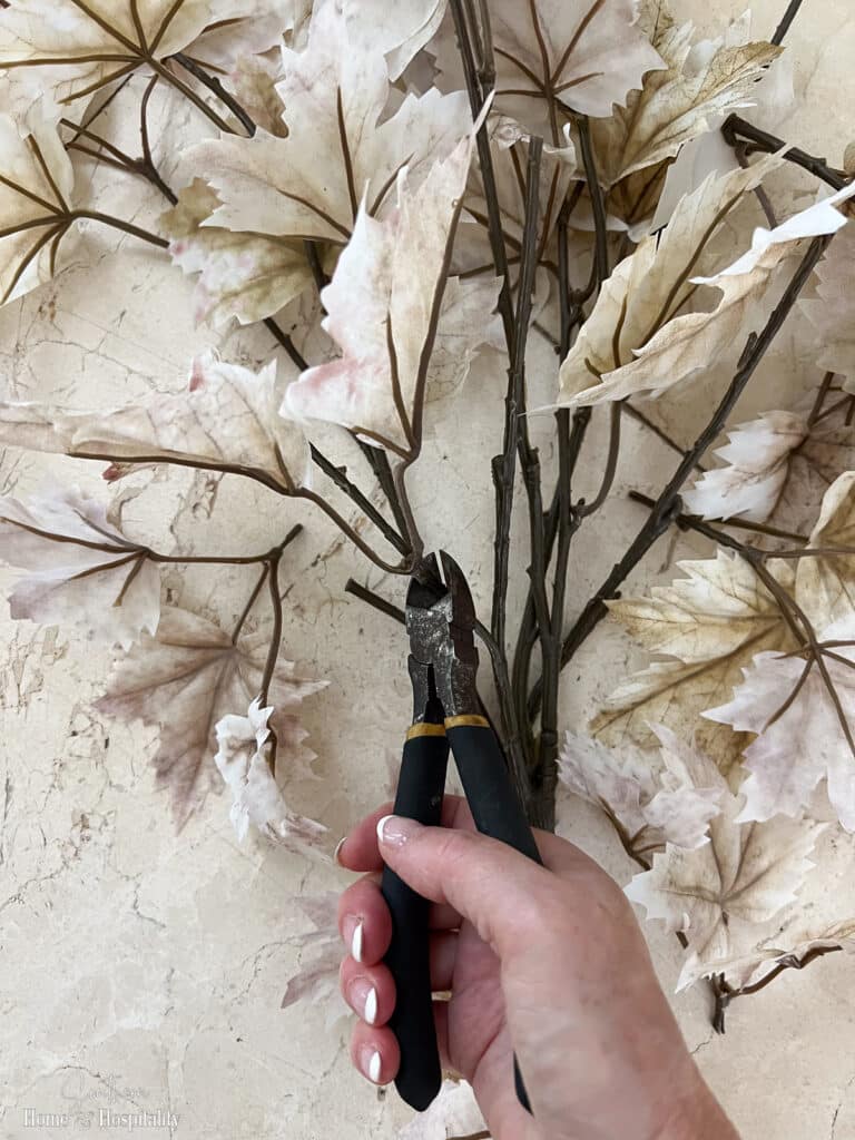 Cutting apart faux fall leaves to make fall branch decor