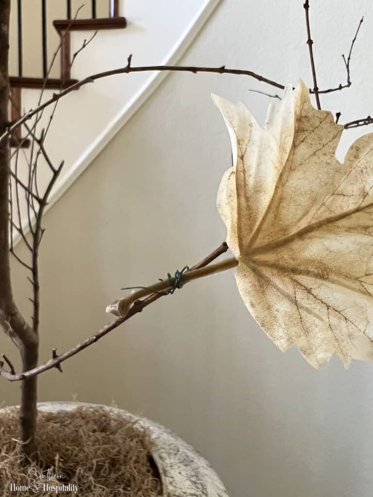 Faux leaf wired onto real branch