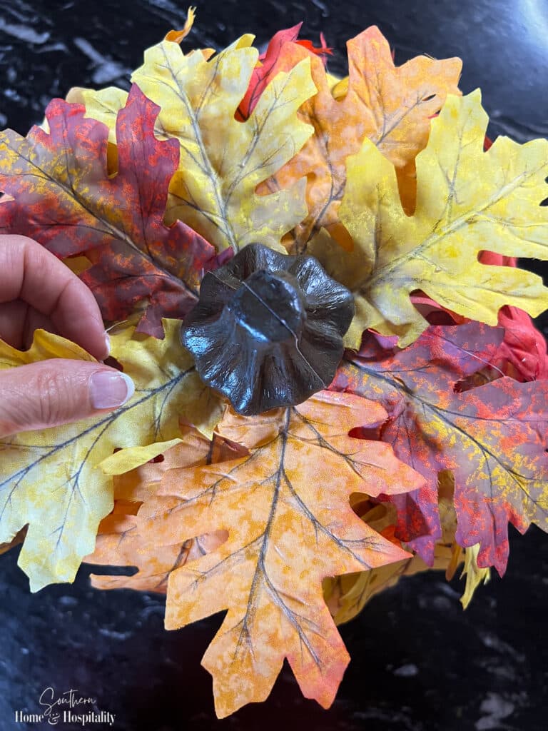 Attaching leaves to a craft pumpkin