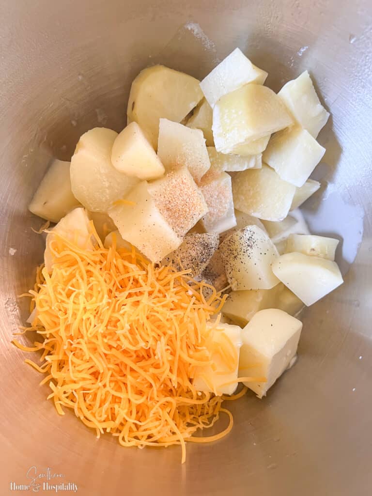 cubed cooked potatoes, butter, cheese, half and half, and spices in mixing bowl