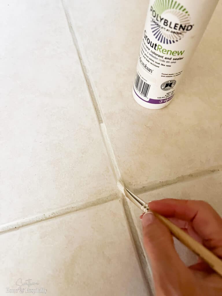Applying grout restorer to grout lines with paint brush