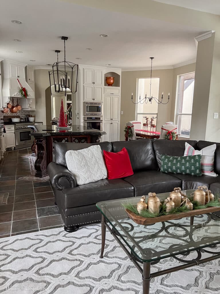 Family room with cozy Christmas pillows and vintage bell centerpiece