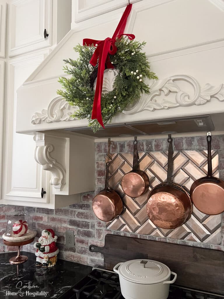 Christmas wreath over cooktop in French country kitchen