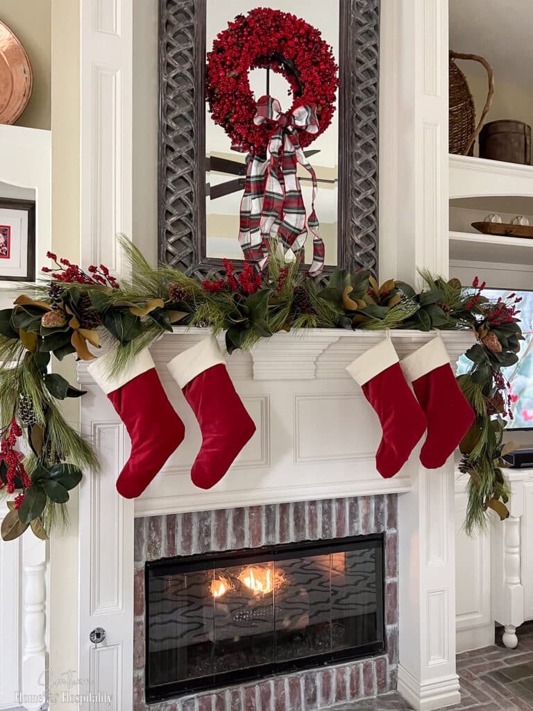 Pottery Barn red and ivory velvet stockings hanging on fireplace mantel