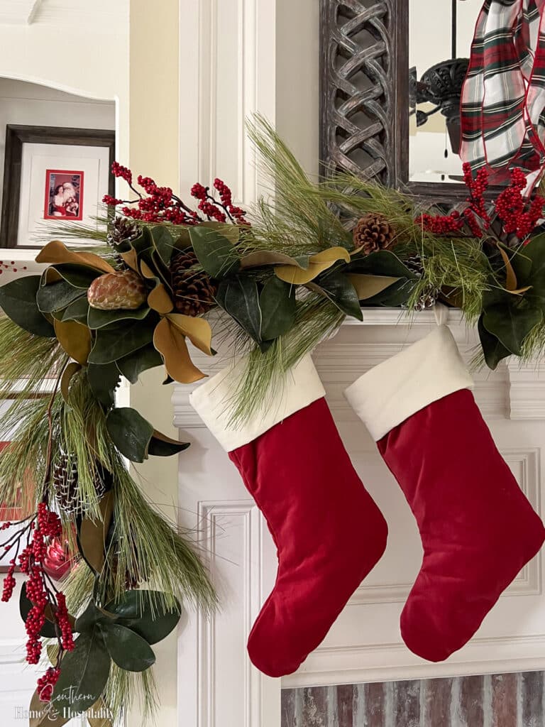 Red and white velvet Christmas stockings above fireplace