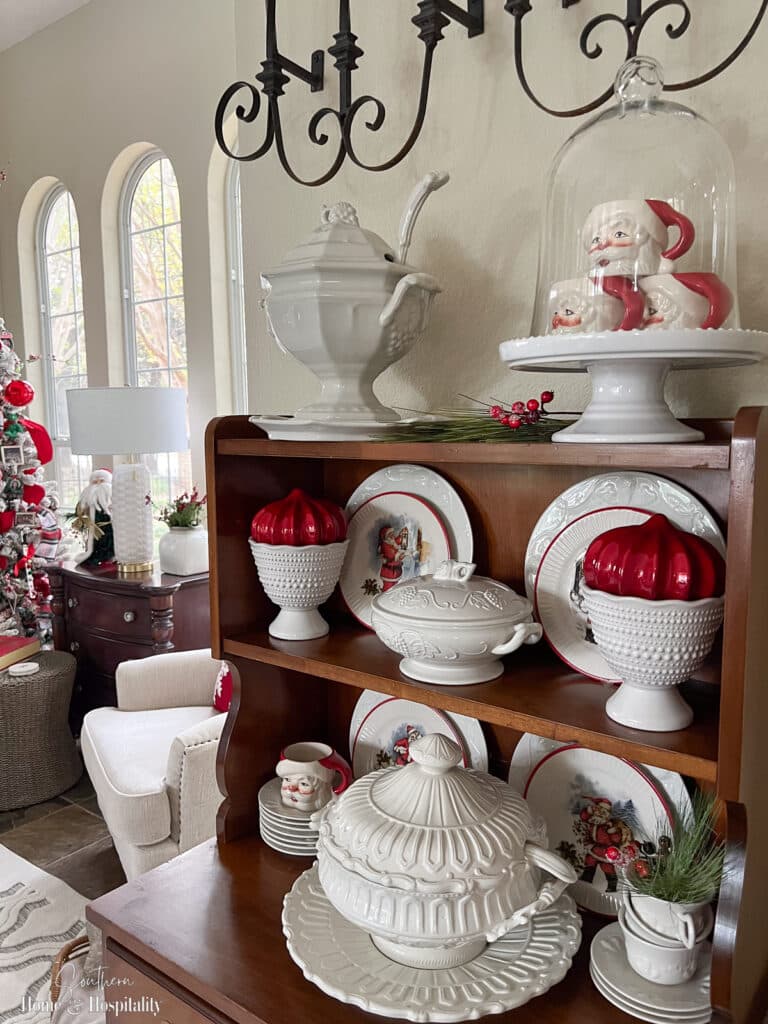 Hutch with white dishes and red Christmas decor