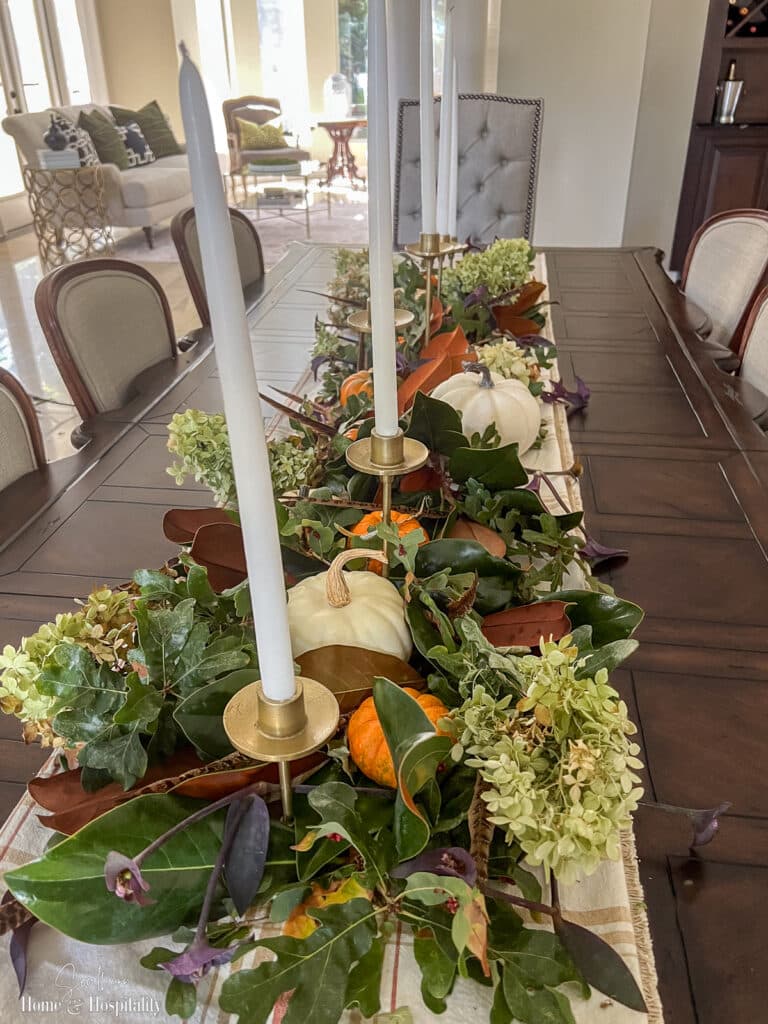 Tall taper candles in Thanksgiving garland centerpiece