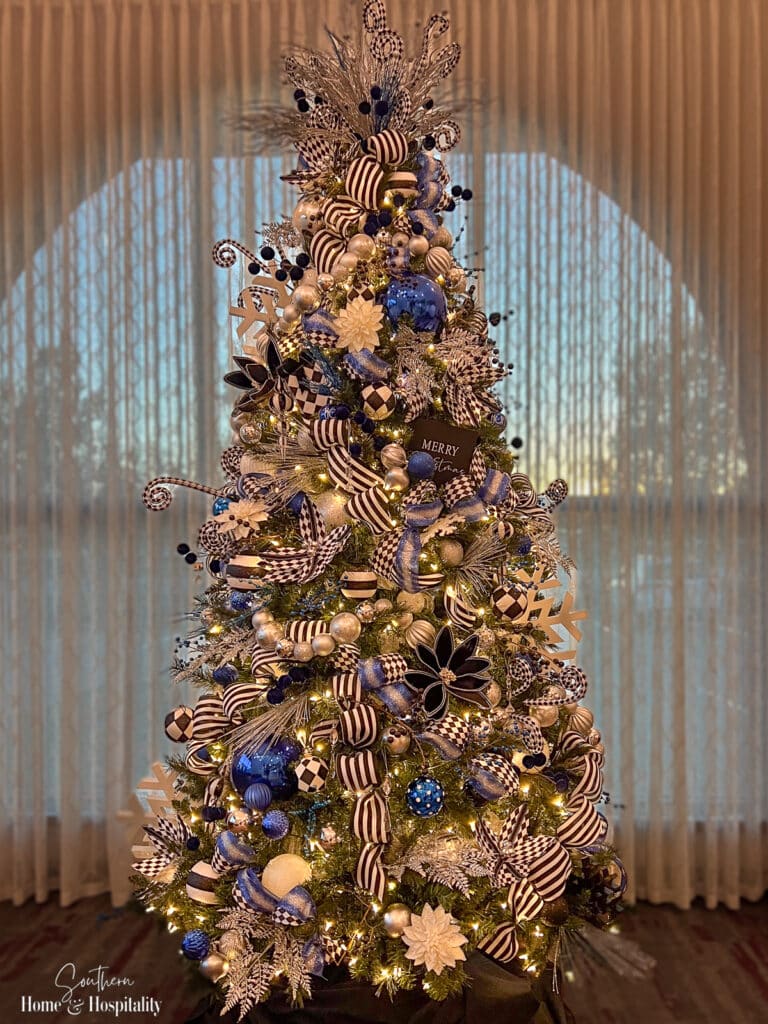 Christmas tree with blue decor and black and white ribbon