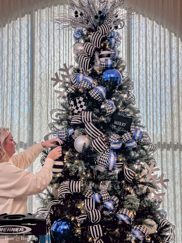 Professional decorator putting ornaments on Christmas tree